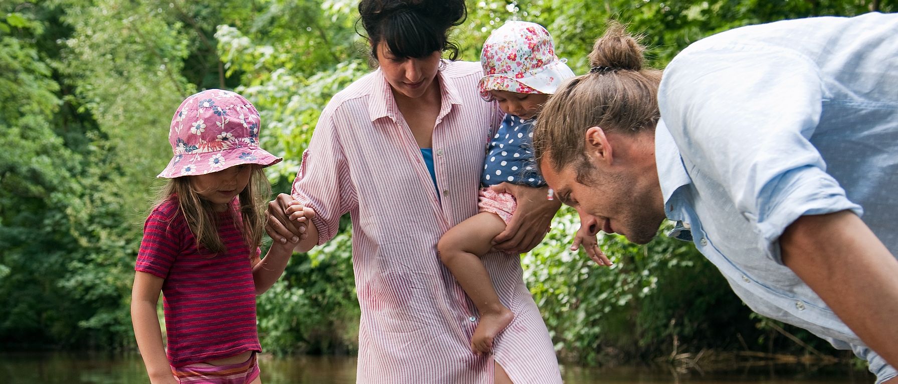family standing in creek