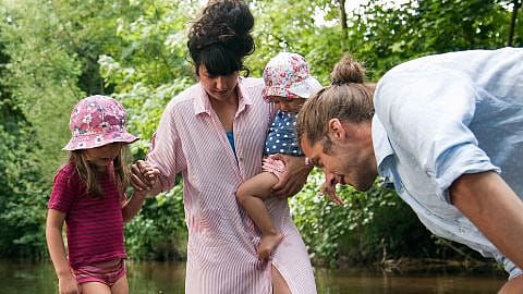 family standing in creek